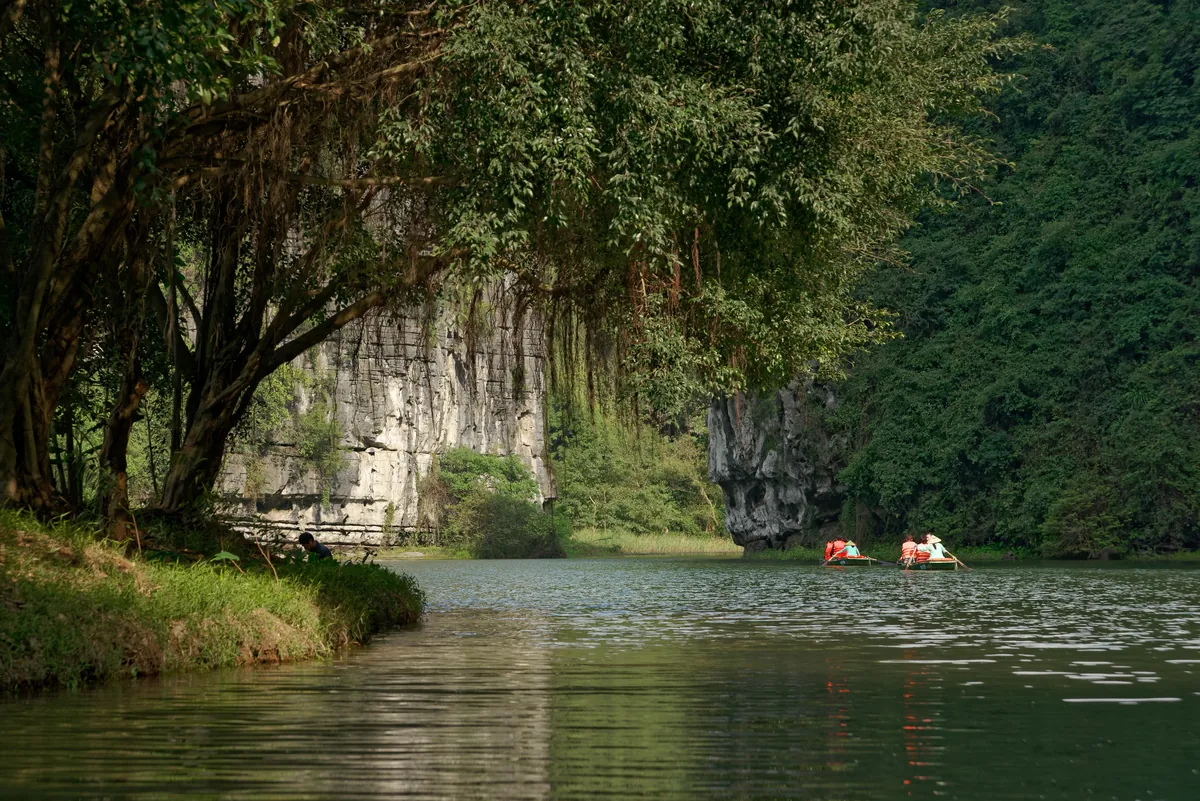 Limestone karst towers reflected in the water at Trang An